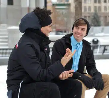 two men talking while sitting on bench