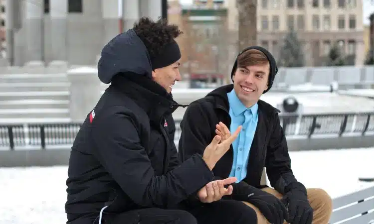 two men talking while sitting on bench